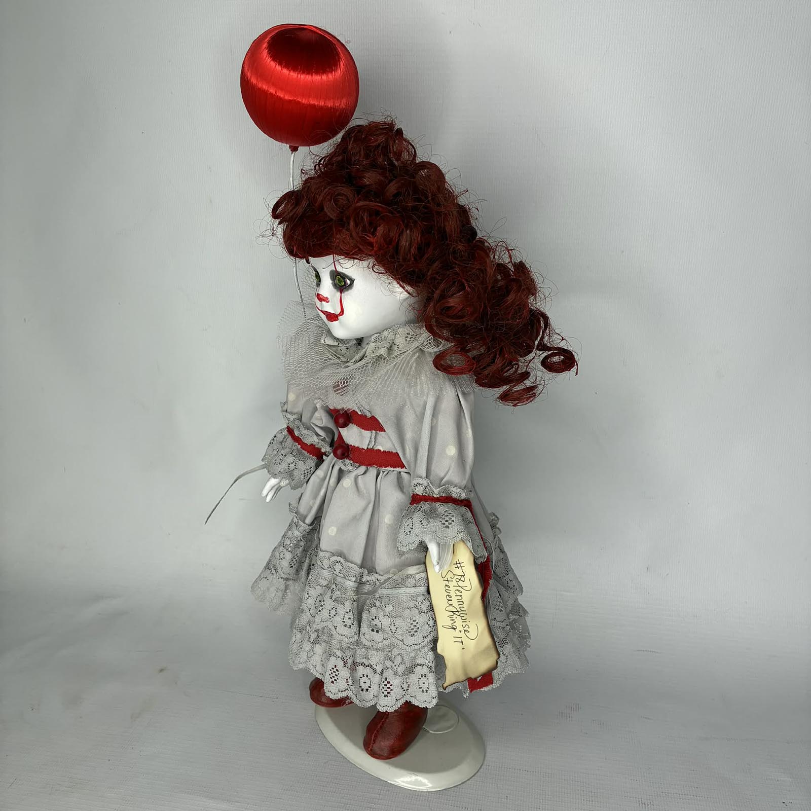 Creepy clown doll with iconic red balloon Pennywise